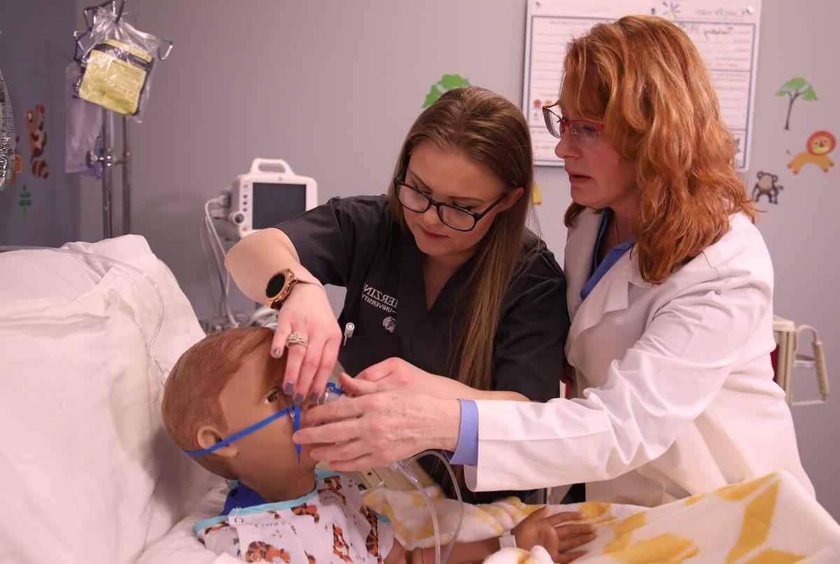 实习护士到注册护士的实习护士与老师学习如何使用氧气面罩